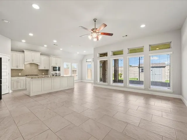 a view of an empty room with kitchen and kitchen view