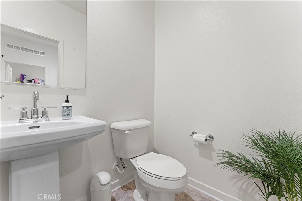 12704 Ironstone Way Moreno Valley, CA 92555 - Photo 15 of 38 a bathroom with a toilet a sink and mirror
