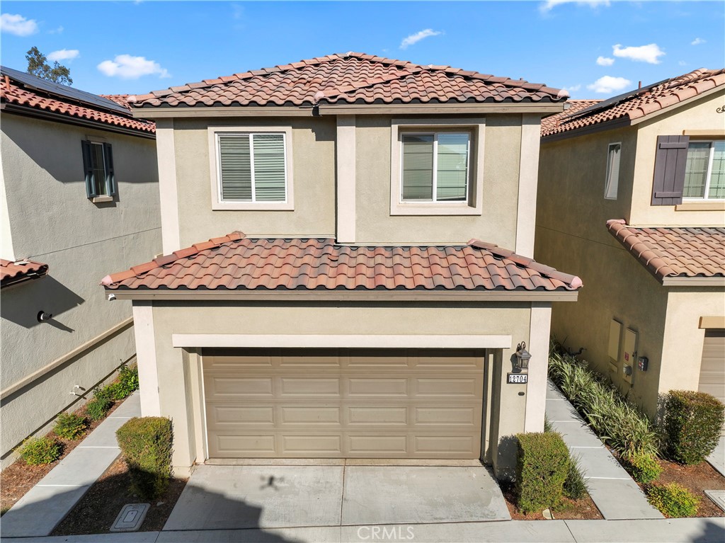 12704 Ironstone Way Moreno Valley, CA 92555 - Photo 2 of 38 a front view of a house with garden