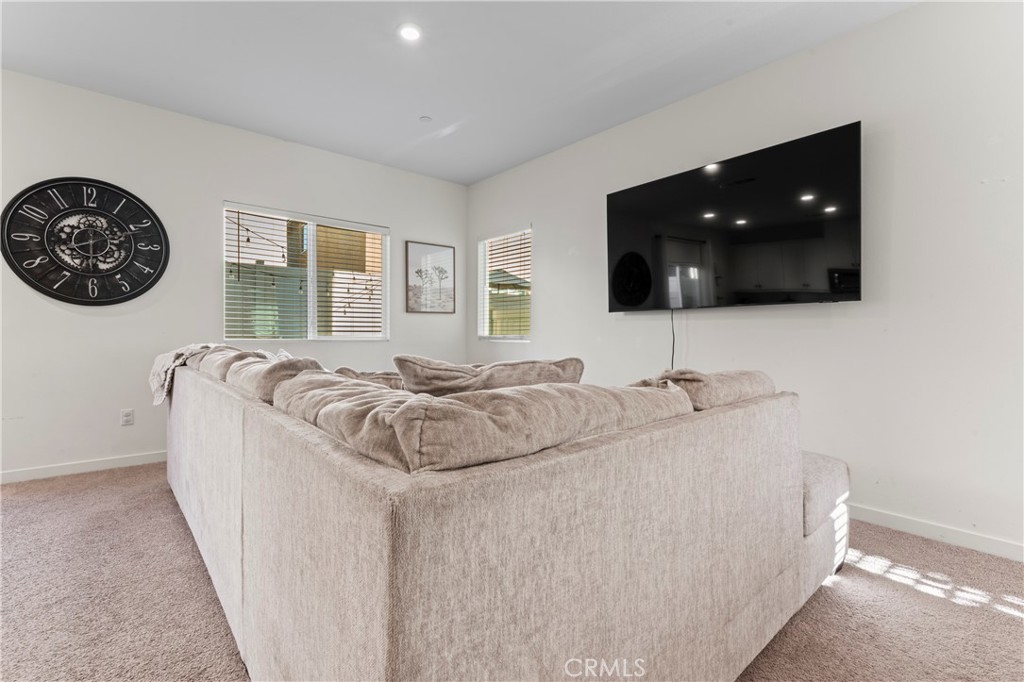 12704 Ironstone Way Moreno Valley, CA 92555 - Photo 21 of 38 a living room with a bed furniture and a flat screen tv