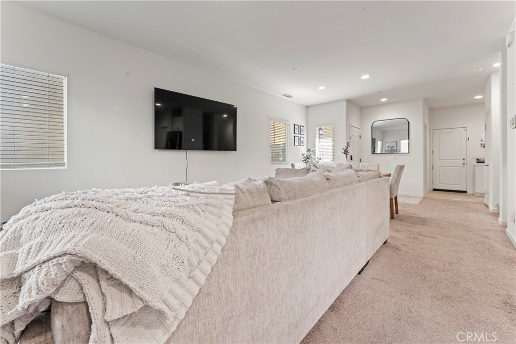12704 Ironstone Way Moreno Valley, CA 92555 - Photo 22 of 38 a large bedroom with a bed a flat screen tv and a couch