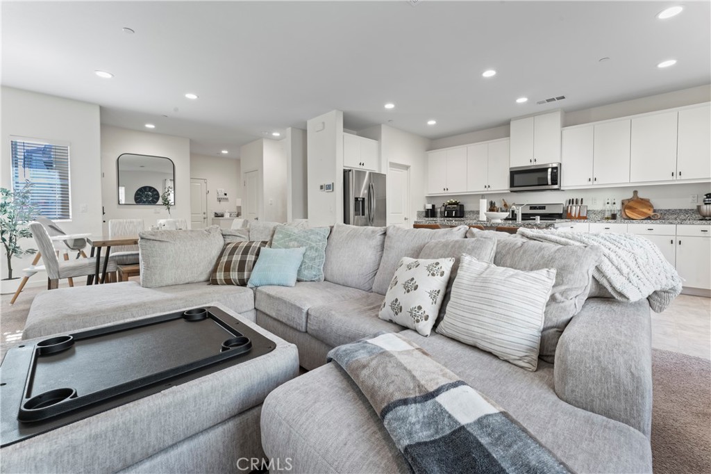 12704 Ironstone Way Moreno Valley, CA 92555 - Photo 23 of 38 a living room with furniture white kitchen and a refrigerator