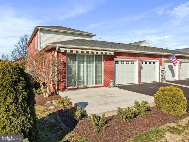 a view of an empty room with chandelier fan and windows