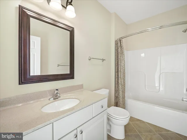 an empty room with a chandelier fan and windows