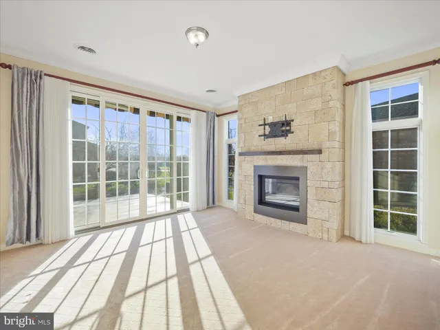 a view of an empty room with a fireplace and a window