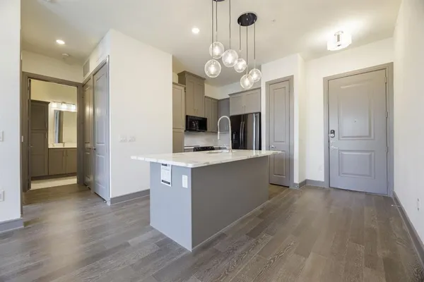 a large kitchen with stainless steel appliances a large center island and cabinets