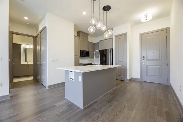 a large kitchen with stainless steel appliances a large center island and cabinets