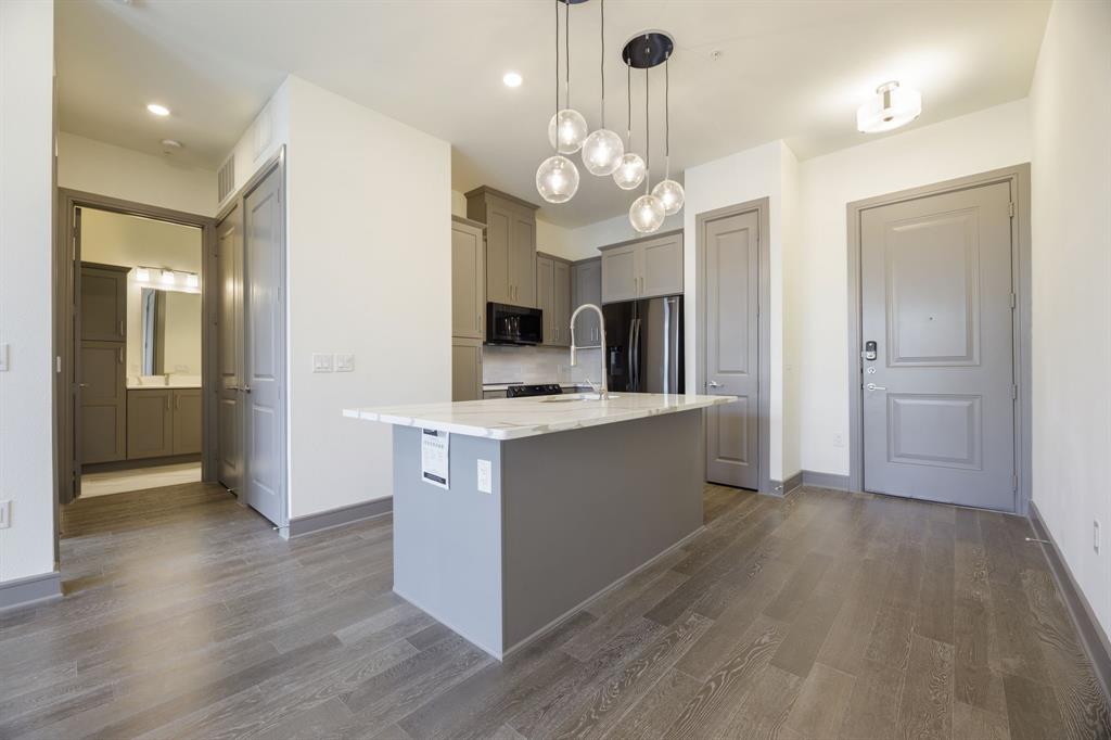 a large kitchen with stainless steel appliances a large center island and cabinets