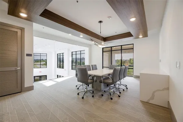 a dining room with furniture a chandelier and wooden floor
