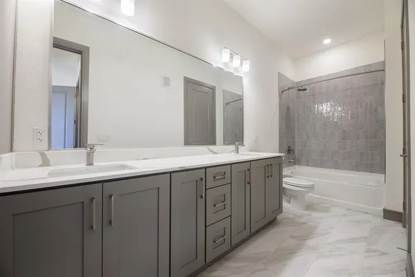 a bathroom with double sink and a mirror