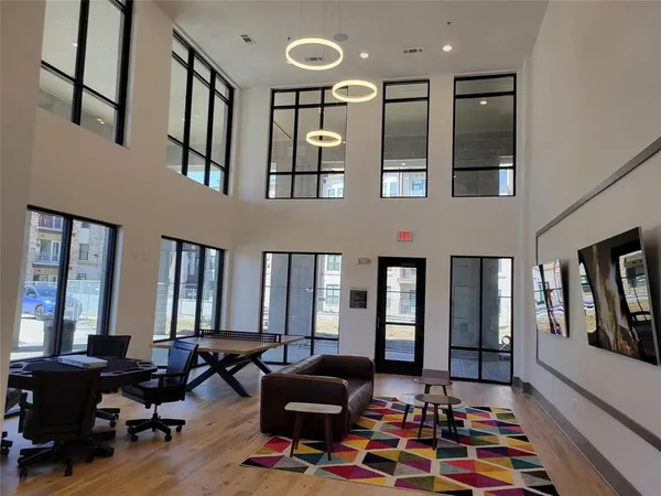 a living room with furniture large window and flat screen tv