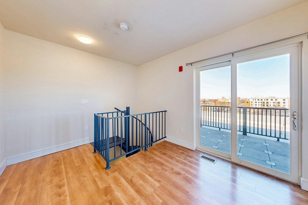 446 Cambridge Street, Unit 406 Boston, MA 02134 - Photo 5 of 7 a view of a room with wooden floor and a window