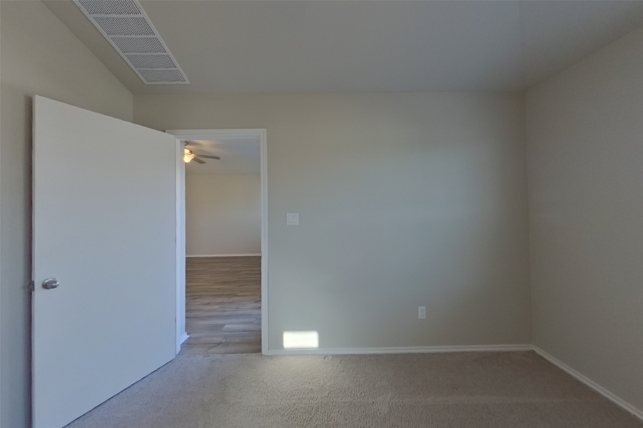3525 Catlett Crk Road Georgetown, TX 78626 - Photo 7 of 16 A spacious bedroom features soft neutral carpeting and leads directly to adjoining wood-look flooring.