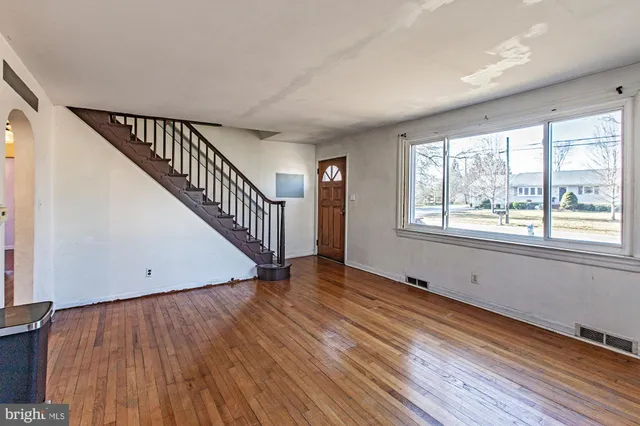 a kitchen with stainless steel appliances granite countertop a refrigerator a stove top oven a sink dishwasher and white cabinets with wooden floor