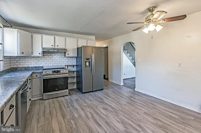 a kitchen with a stove a refrigerator and a window