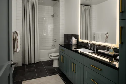 a bathroom with a granite countertop sink a toilet and a mirror