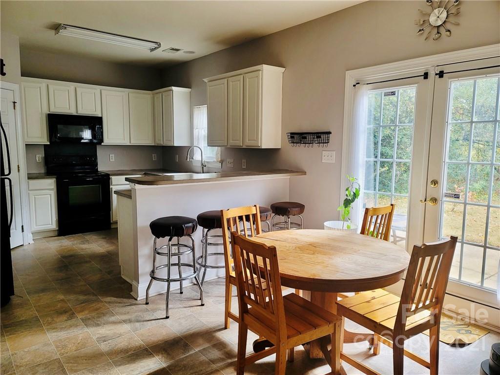 11402 Woodfire Road Charlotte, NC 28269 - Photo 14 of 24 a kitchen with stainless steel appliances granite countertop a stove a refrigerator a sink a table and chairs