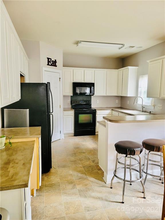 11402 Woodfire Road Charlotte, NC 28269 - Photo 15 of 24 a kitchen with stainless steel appliances kitchen island granite countertop a refrigerator and a stove top oven