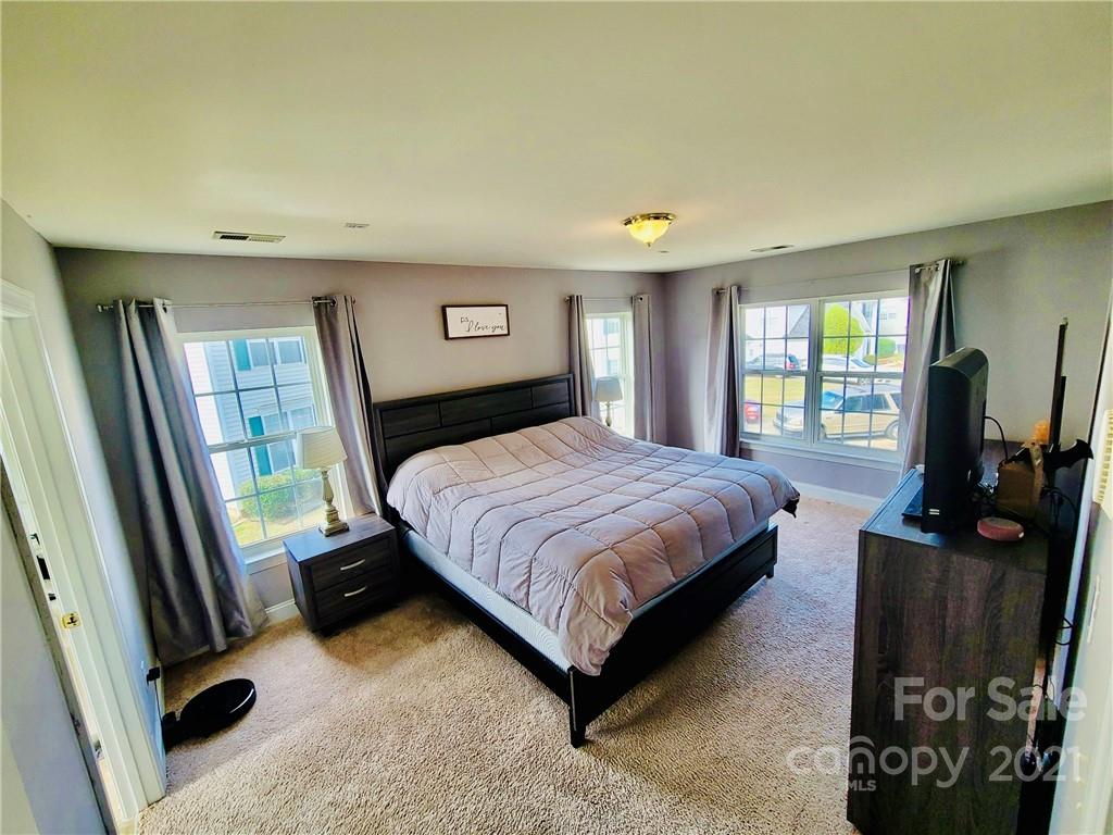 11402 Woodfire Road Charlotte, NC 28269 - Photo 16 of 24 a bedroom with a bed flat screen tv and window