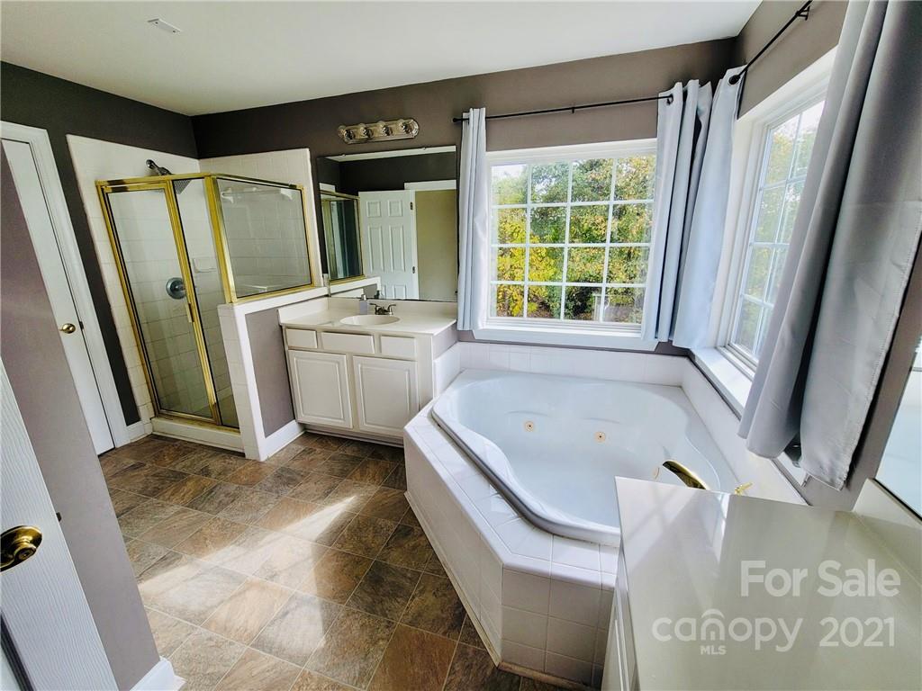 11402 Woodfire Road Charlotte, NC 28269 - Photo 17 of 24 a bathroom with a tub sink and mirror