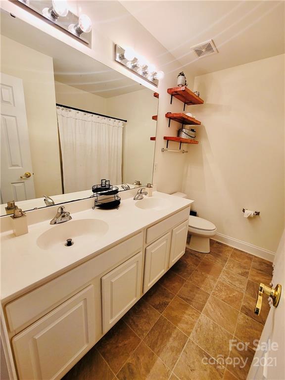 11402 Woodfire Road Charlotte, NC 28269 - Photo 21 of 24 a bathroom with a double vanity sink mirror and
