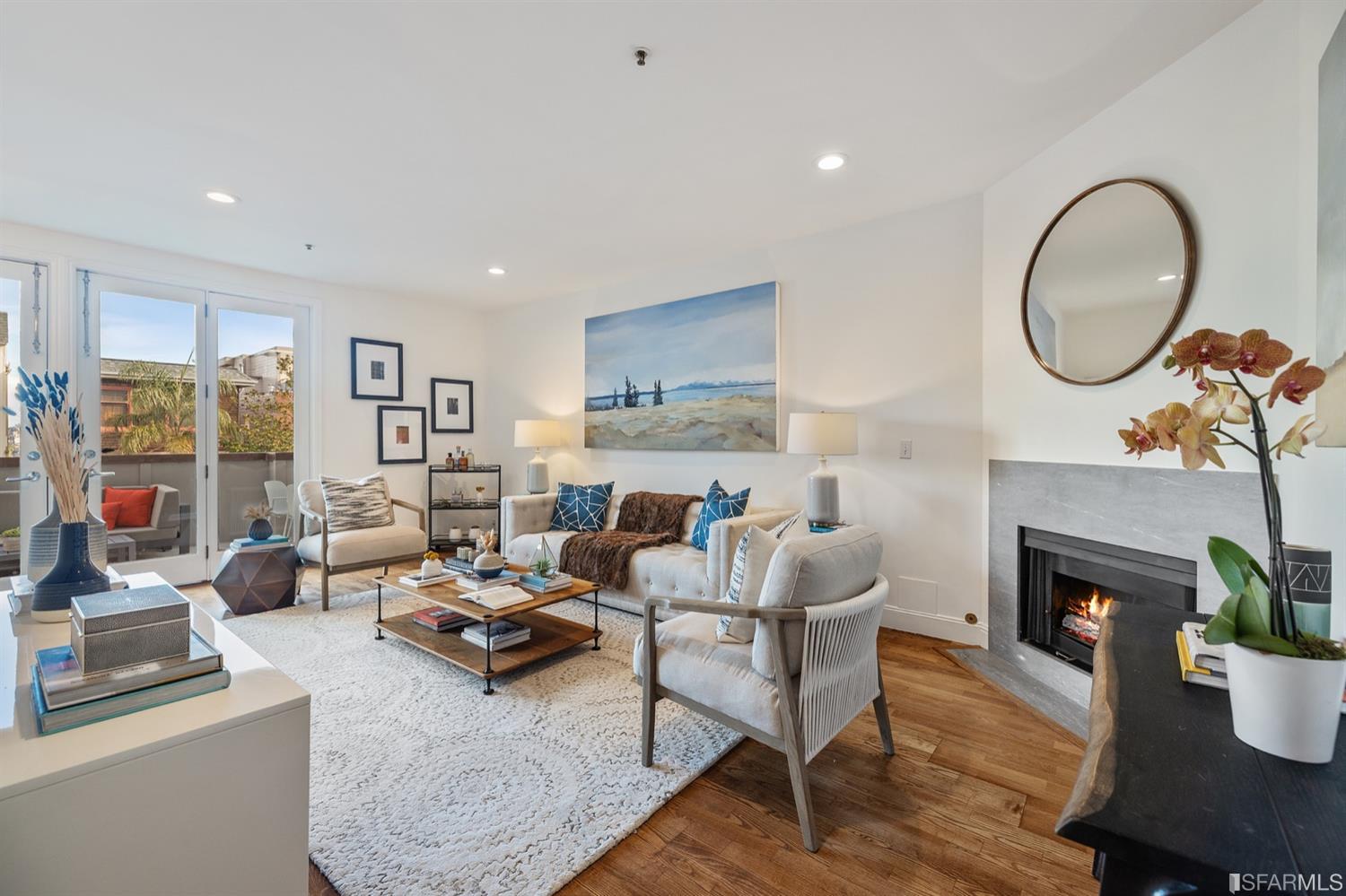 a living room with furniture a fireplace and a large window