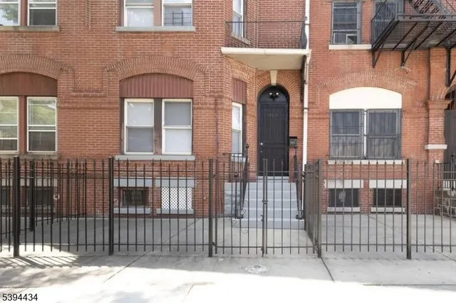a front view of a house with a iron gate