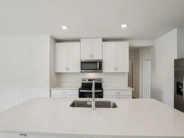 a kitchen with granite countertop a stove and a sink