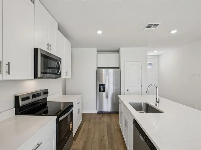a kitchen with a sink a stove and refrigerator
