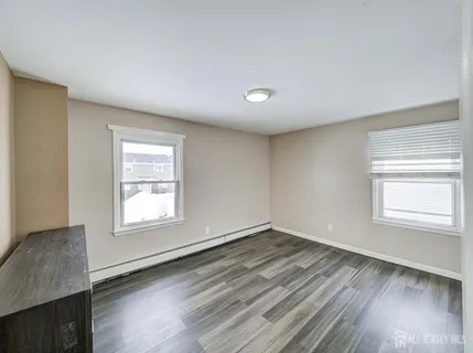 an empty room with wooden floor and closet