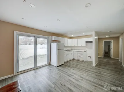 a view of a hallway with wooden floor and a bathroom