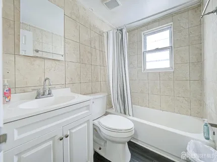 an empty room with wooden floor closet and windows