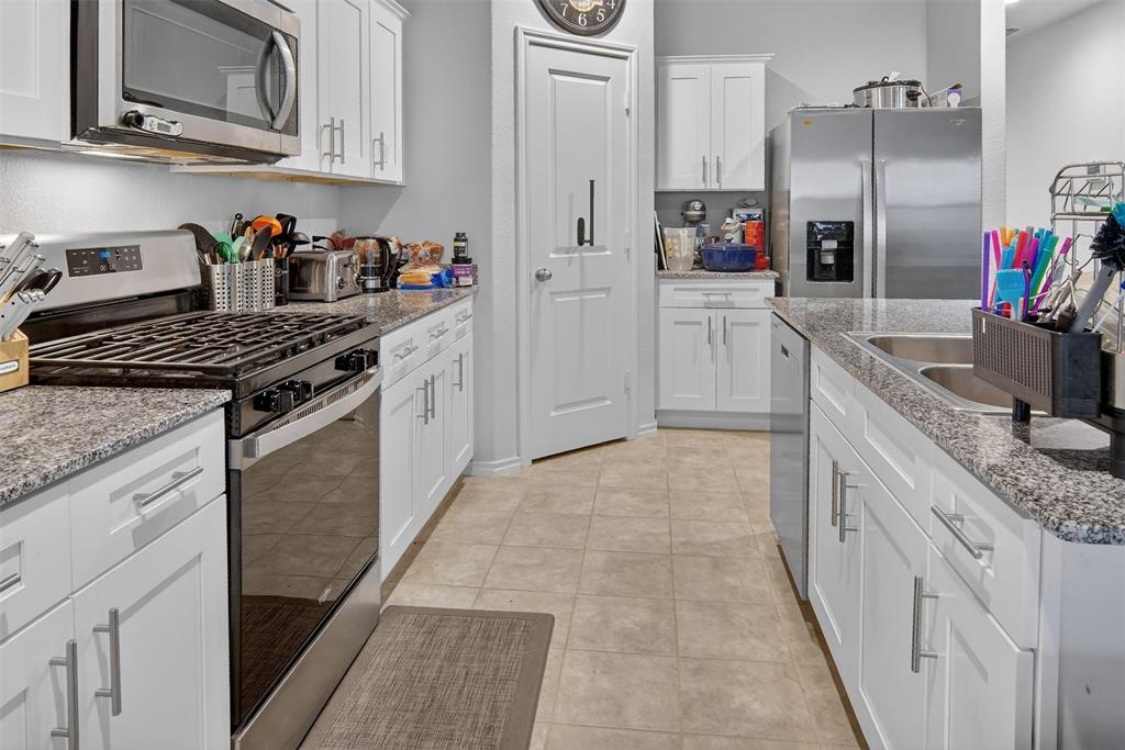 536 Bronze Circle East Springtown, TX 76082 - Photo 12 of 28 a kitchen with stainless steel appliances granite countertop a sink stove and refrigerator