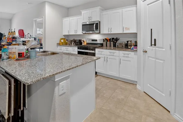 a kitchen with stainless steel appliances granite countertop a sink dishwasher and cabinets with wooden floor