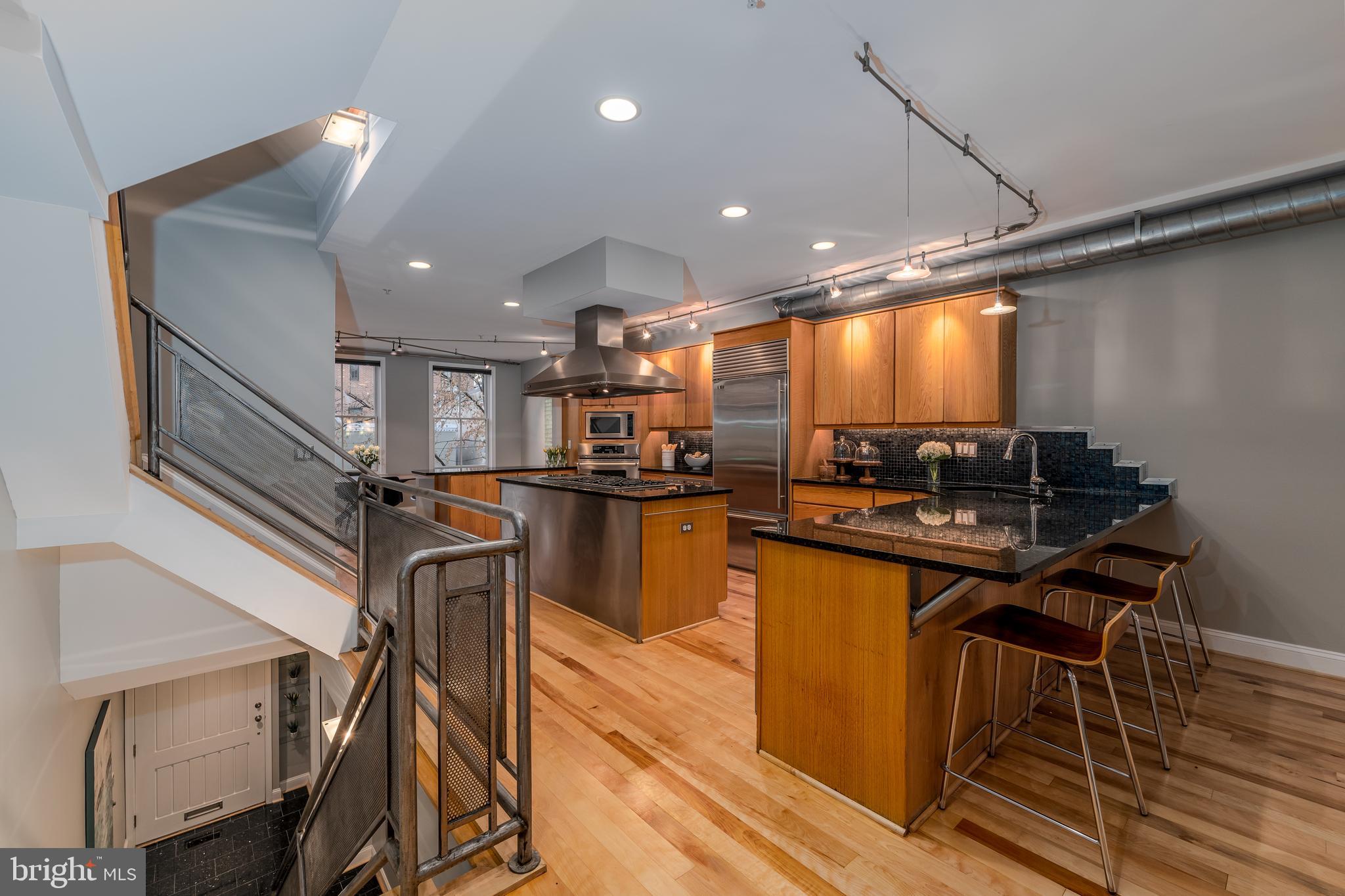 1715 Lancaster Street Baltimore, MD 21231 - Photo 2 of 68 a kitchen with stainless steel appliances kitchen island granite countertop a table chairs in it and wooden floors