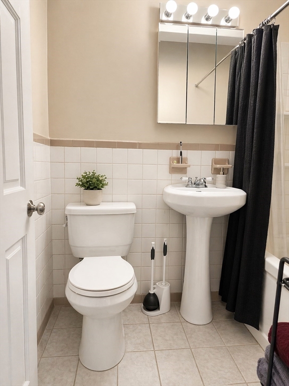 116 Spring Street, Unit A8 Boston, MA 02132 - Photo 3 of 3 a white toilet sitting next to a bathroom sink