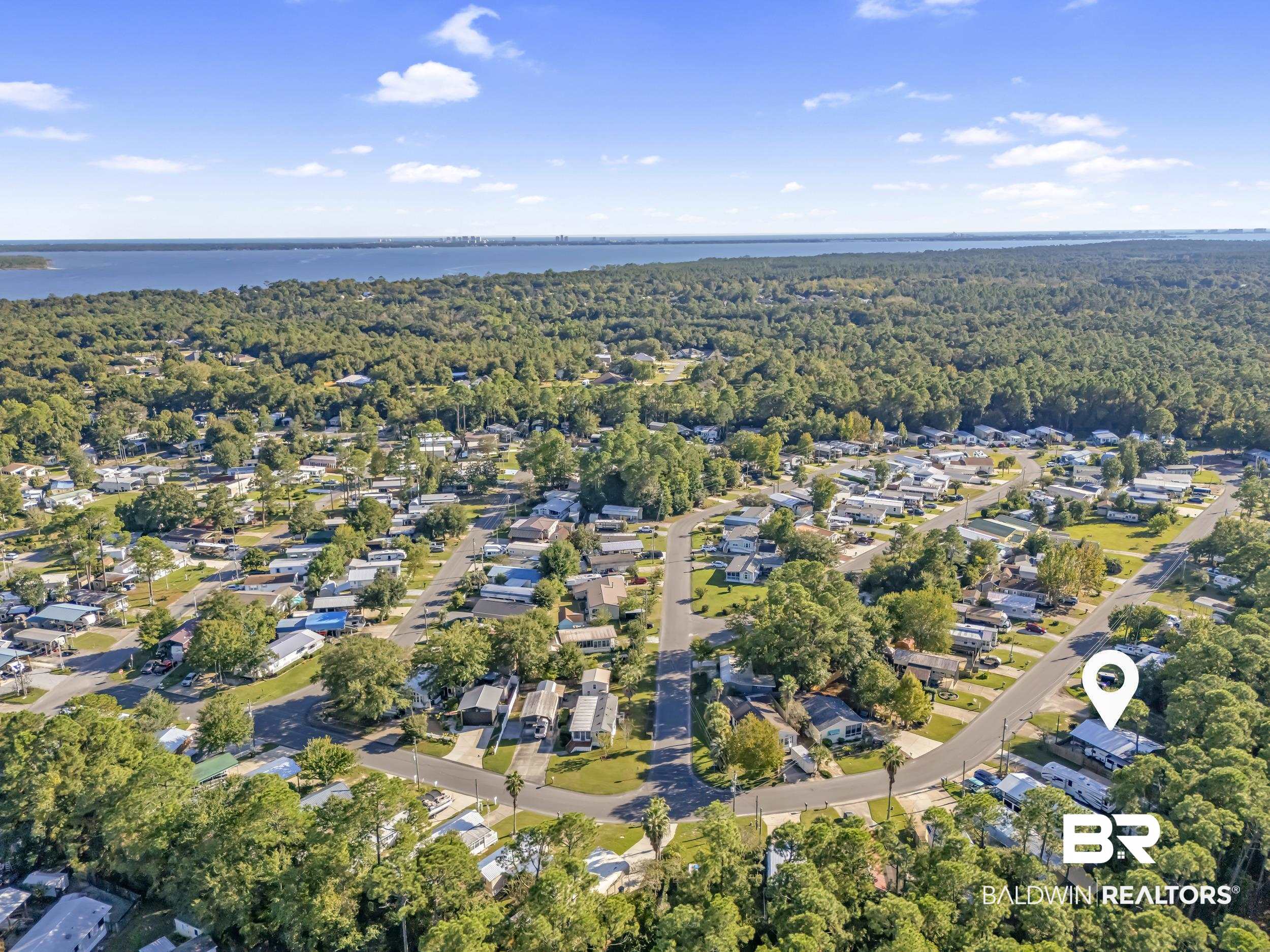 182 Defuniak Loop Lillian, AL 36549 - Photo 16 of 21 Aerial view of residential area featuring a heavily wooded area and a large body of water