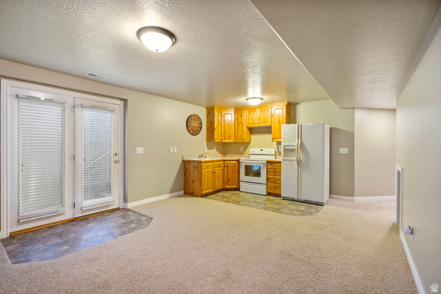 557 South 1470th Street East Springville, UT 84663 - Photo 28 of 46 Kitchen featuring a textured ceiling, white appliances, light carpet, and light countertops