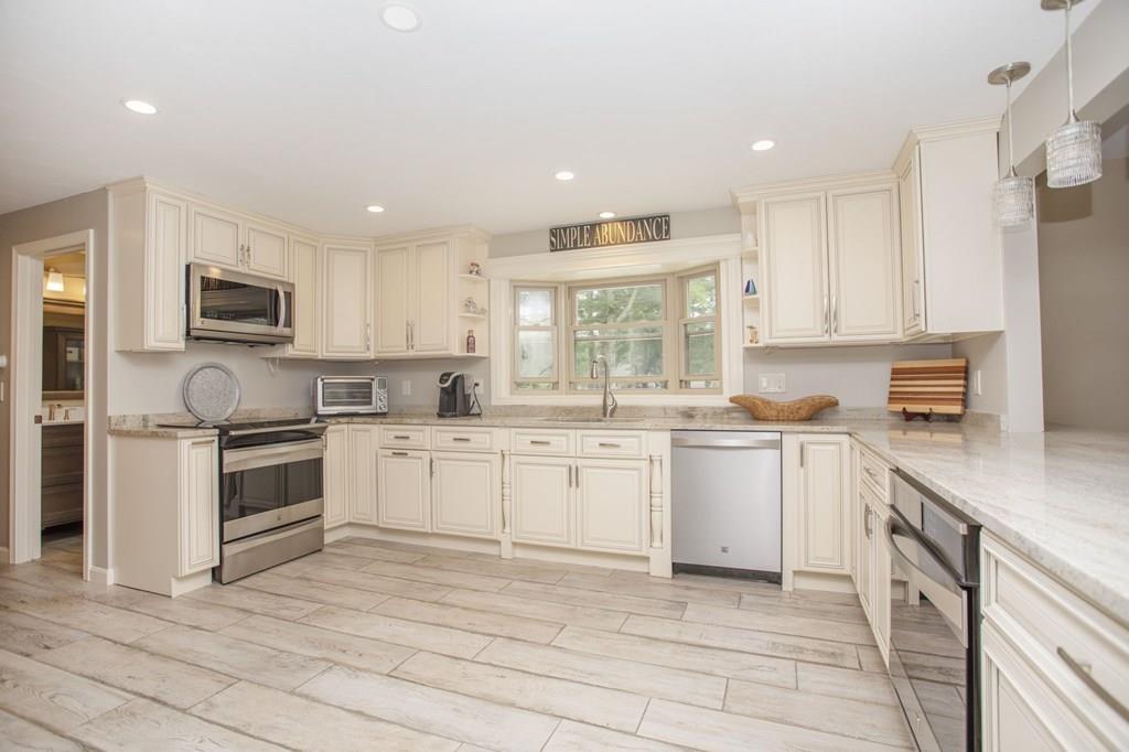 344 Walnut Plain Road Rochester, MA 02770 - Photo 8 of 42 a kitchen with granite countertop white cabinets a stove a sink and a oven
