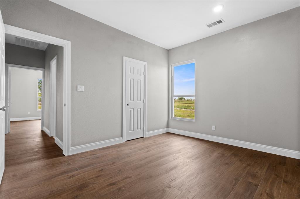 7074 Northeast County Road Rice, TX 75155 - Photo 8 of 22 a view of an empty room with wooden floor and window