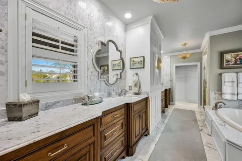 a bathroom with a granite countertop double vanity sink and a window
