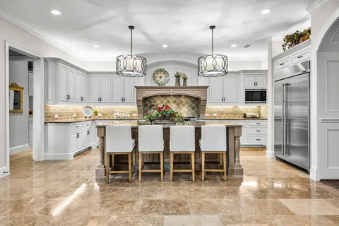 a kitchen with kitchen island a dining table and chairs