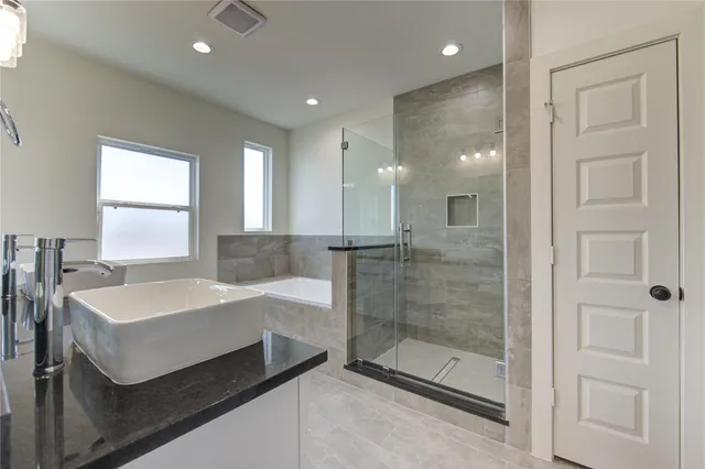 a bathroom with a sink a toilet and shower