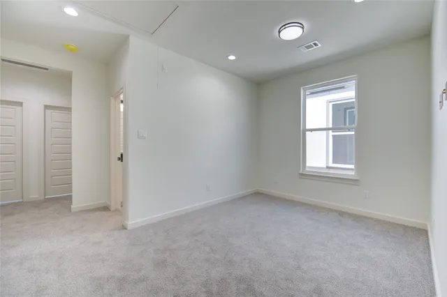 an empty room with a window and a bathroom
