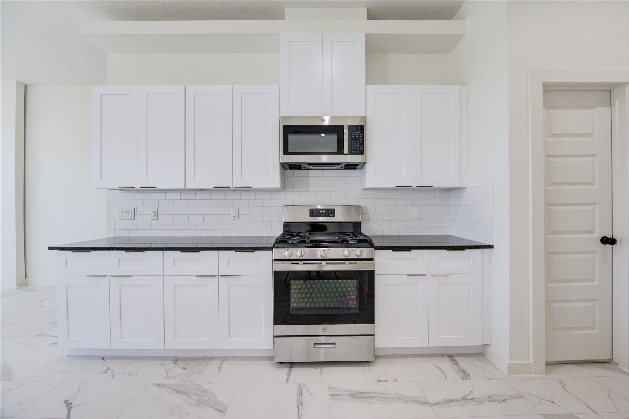 2912 El Fenice Lane Houston, TX 77057 - Photo 37 of 49 a kitchen with granite countertop white cabinets and stainless steel appliances