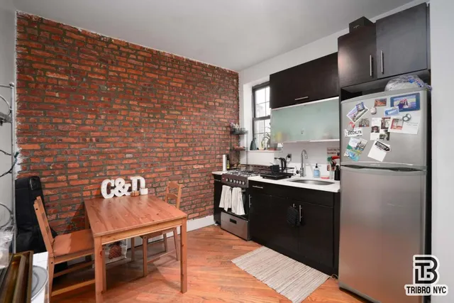 a kitchen with stainless steel appliances granite countertop a refrigerator table and chairs