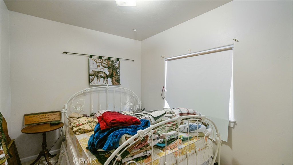 22070 Big Oak Road Cedarpines Park, CA 92322 - Photo 43 of 58 a bedroom with a bed and a painting on the wall