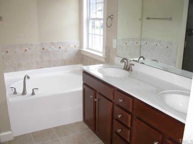 152 Sharp Top Trail Apex, NC 27502 - Photo 10 of 10 a bathroom with a tub sink and mirror