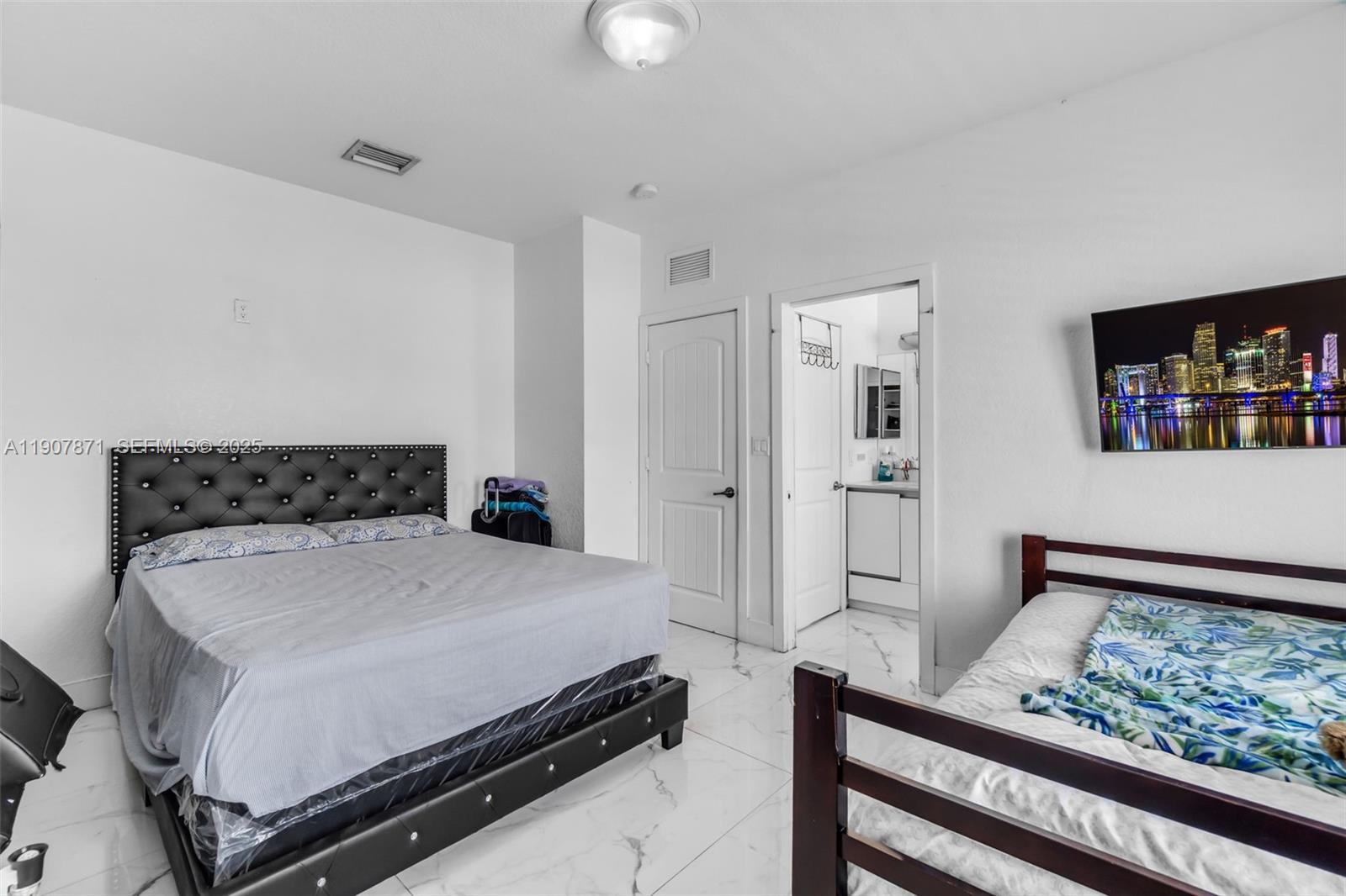 13381 Southwest 269th Street Homestead, FL 33032 - Photo 29 of 44 a bedroom with a bed and a flat screen tv