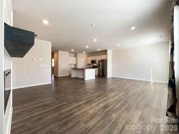a view of empty room with wooden floor and fireplace